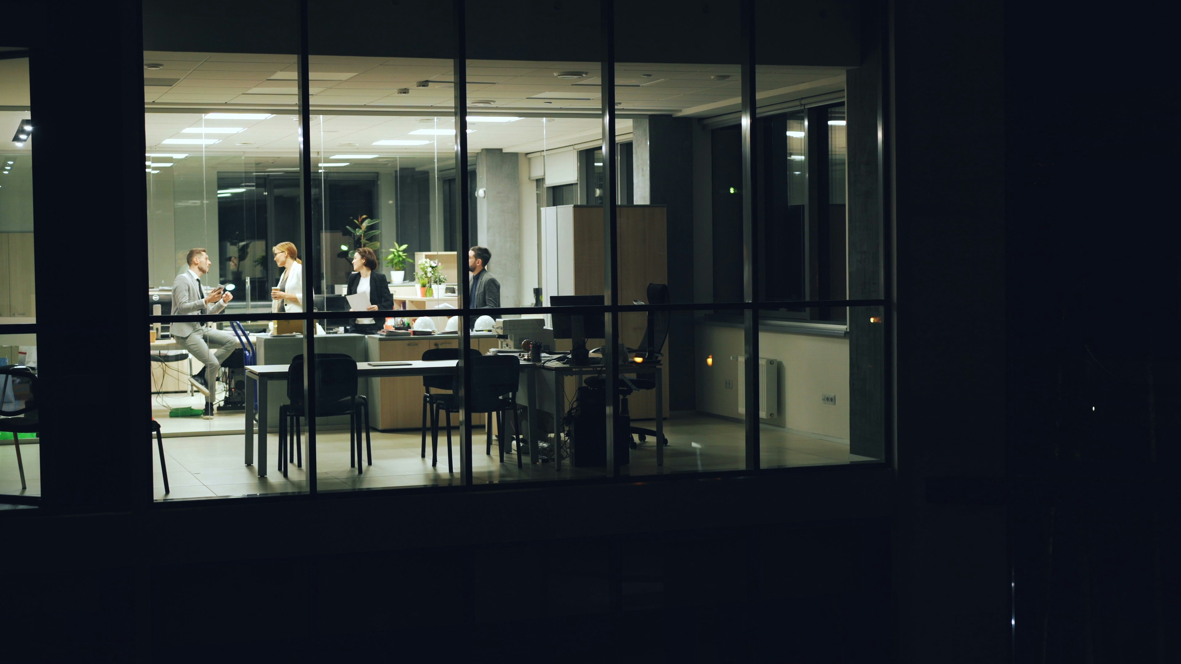 people working late in a modern office illuminated by LED lighting at night