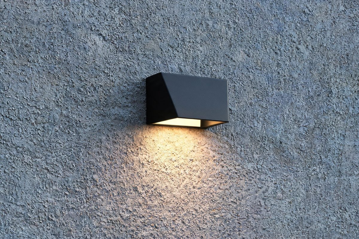 Outdoor wall light fixture mounted on commercial building exterior providing accent lighting
