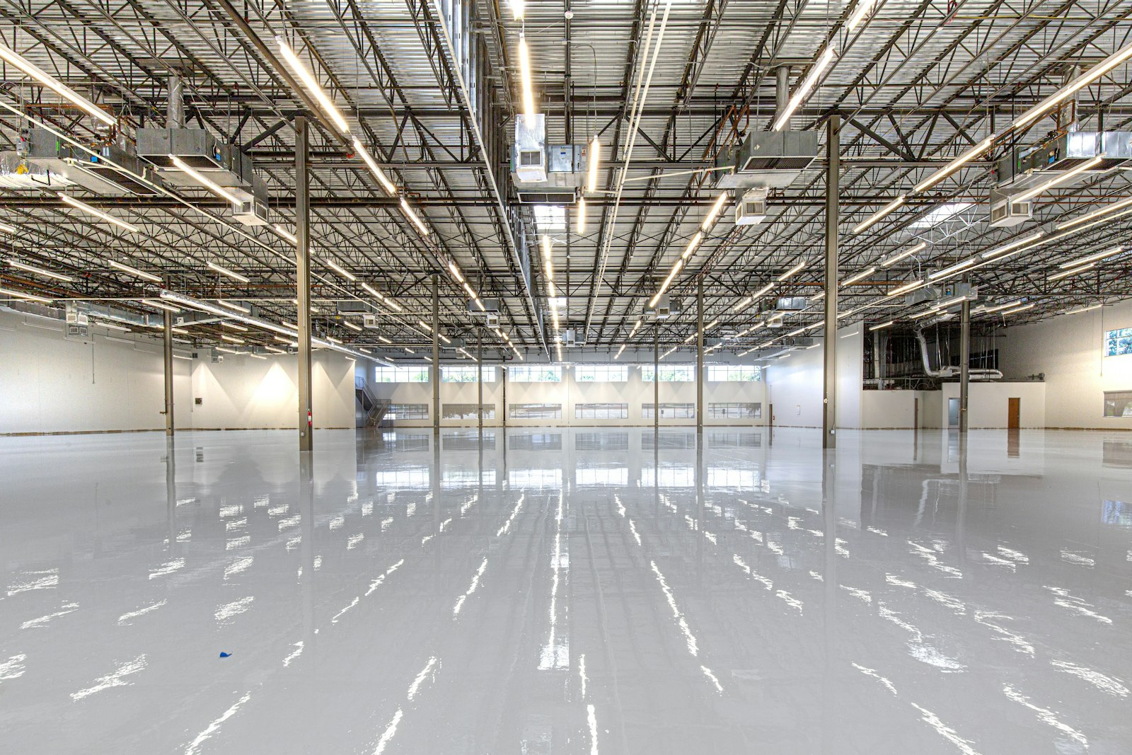 Large warehouse interior with bright overhead LED lighting and storage racks