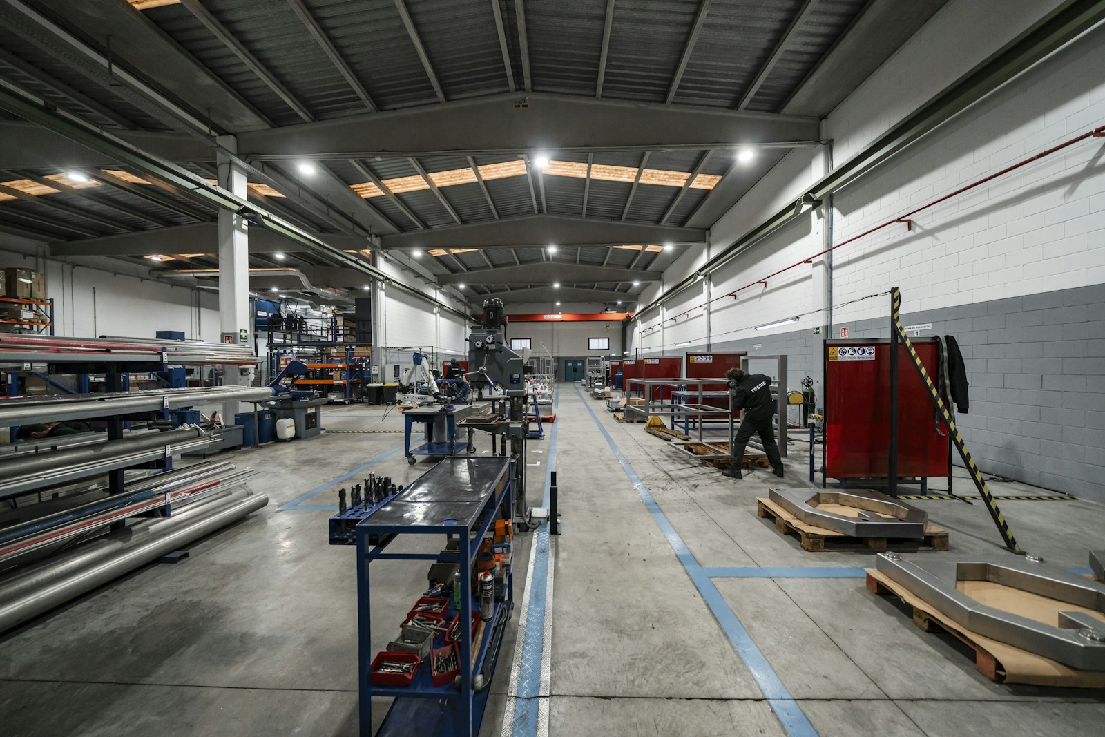 factory floor with workers and machinery lit by high-bay LED lighting at production height