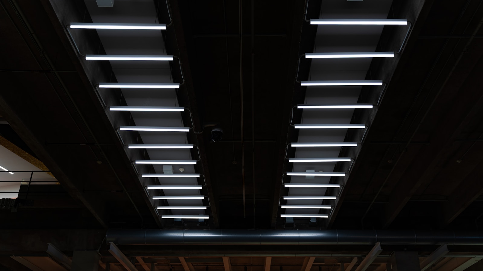 rows of legacy fluorescent ceiling lights being replaced by LED high-bay retrofits