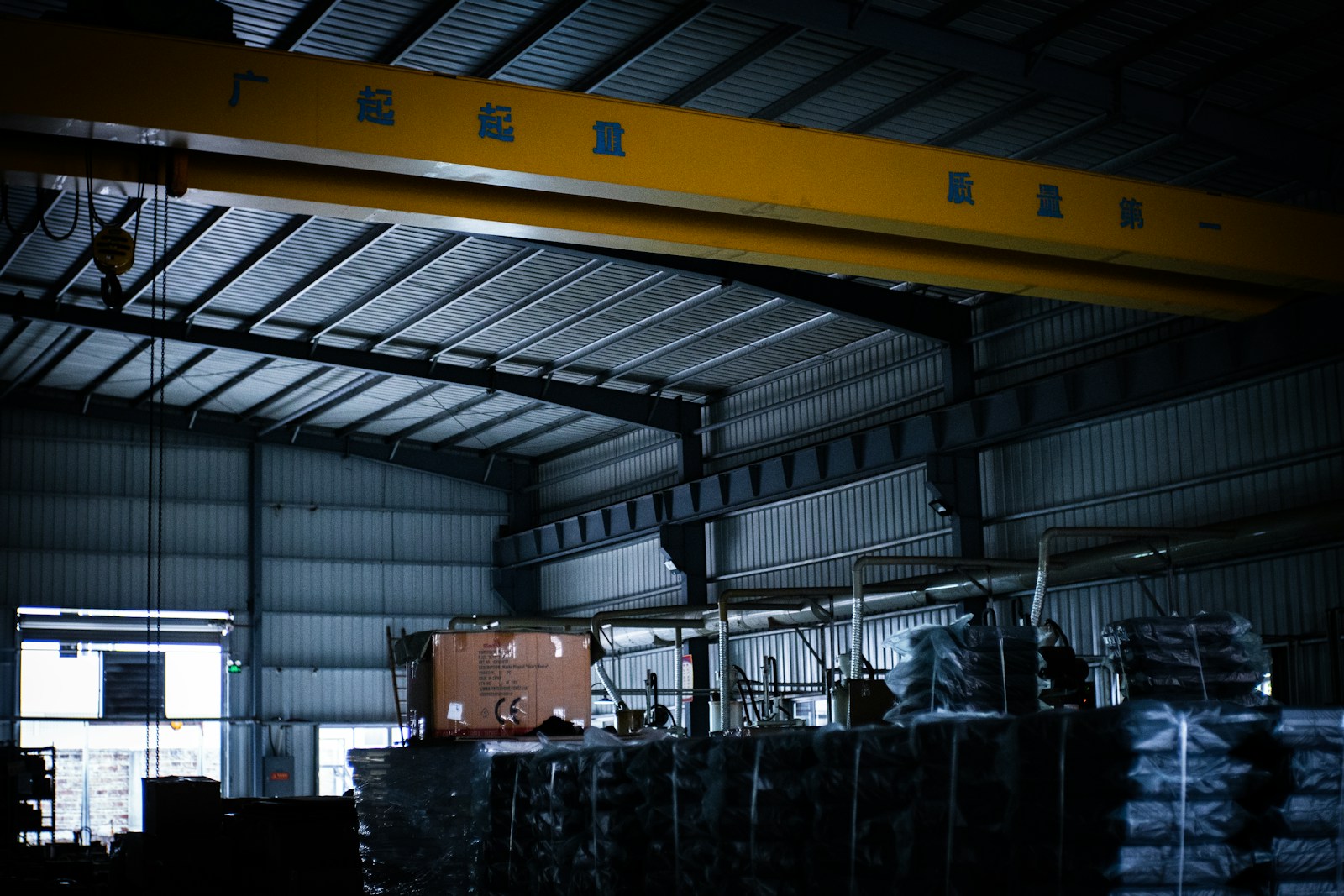 warehouse with tall pallet racking aisles where linear high-bay fixtures prevent shelf shadowing