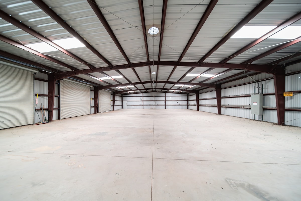 large empty warehouse with bright LED lighting showing even illumination across the entire floor space
